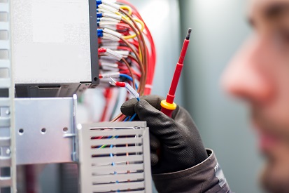 Électricien travaillant sur un tableau électrique dans une maison